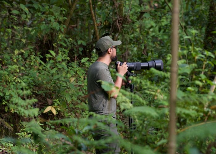 Naturfotograf mit langem Teleobjektiv im dichten Wald